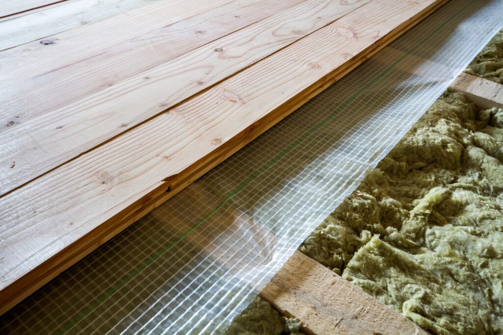 Installation of new floor of wooden natural planks and mineral wool insulation for isolation and